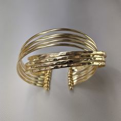 Kizzy golden brass cuff with detailed hammering for glam Adjustable Internal diameter ~2.5-2.7 inches Weight ~42.7 grams Gold Wide Band Metal Cuff Bracelet, Hammered Metal Cuff Bracelet, Gold Brass Cuff Bracelet With Wide Band, Gold Brass Wide Band Cuff Bracelet, Gold Hammered Cuff Bracelet Bangle, Gold Wide Band Cuff Bracelet In Brass, Adjustable Hammered Gold Bangle, Luxury Gold-colored Sterling Silver Cuff Bracelet, Luxury Metal Cuff Bracelet, Tarnish Resistant