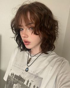 a girl with short hair wearing a white t - shirt