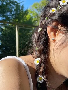 a woman with flowers in her hair is looking down at something on the ground behind her