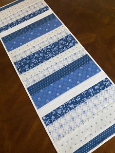 a blue and white table runner on a wooden floor