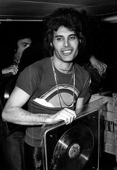 black and white photograph of a man holding a record player