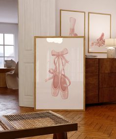 there are pictures on the wall and in front of them, two framed ballet shoes