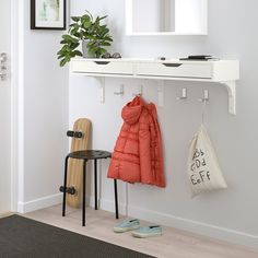 a coat rack with two coats hanging from it's hooks next to a pair of shoes