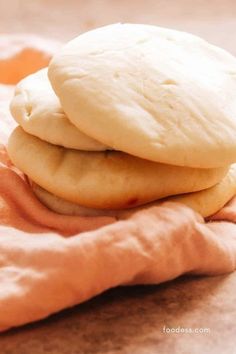 two cookies sitting on top of each other on a pink cloth next to an orange towel