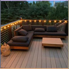 a couch sitting on top of a wooden deck next to a table and lamp post