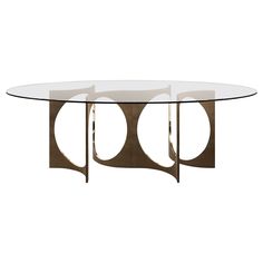 an oval glass table with metal legs and three circles on the top, against a white background