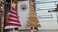 several wooden christmas trees are displayed in front of a white door with an american flag on it