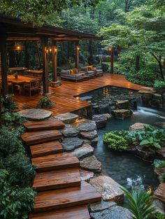 a wooden deck with steps leading up to a small waterfall in the middle of it