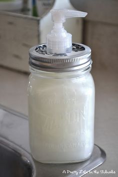 a glass jar with a soap dispenser on it