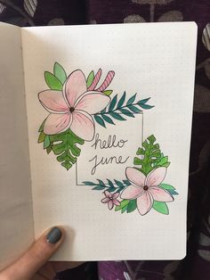 a hand holding a notebook with flowers on it and the words hello june written in cursive writing