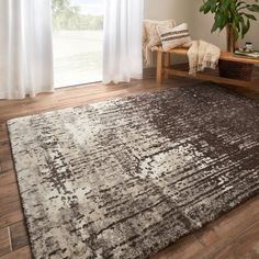 a brown and white area rug in front of a window with curtains on the side