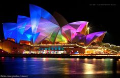 the sydney opera house lit up in blue and purple for vivid lighting on it's facade