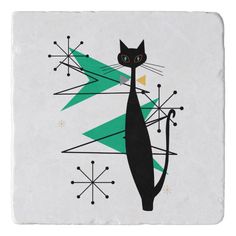 a black cat standing in front of a green christmas tree on a white tile coaster