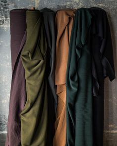 four different colors of clothing hanging on a wall