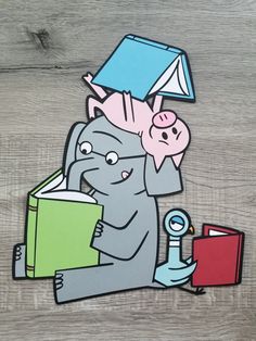 an elephant reading a book while holding a pig