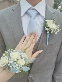 a close up of a person wearing a suit and tie with flowers on his lapel