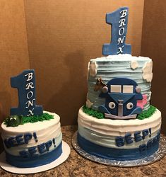 two birthday cakes made to look like trains and cars with the number one on top