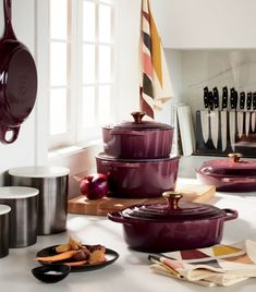 purple pots and pans are sitting on the counter