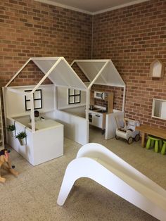 a doll house with furniture and accessories on the floor in front of a brick wall