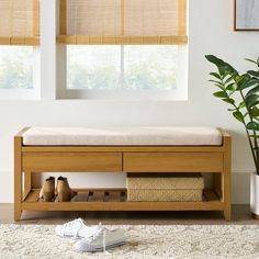 a wooden bench sitting next to a potted plant on top of a white rug