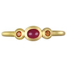 A vibrant oval shaped ruby flanked by sparkling mandarin garnets. This three stone ring is beautifully crafted, bezel set and matte-finished. Wear alone or stacked with other rings to elevate your individual style! Handcrafted in 18k green gold, Faye Kim’s modern design conveys understated elegance and a truly stylish, everyday look. Size 7 All pieces designed and handmade in the US. Model photographed wearing similar style stack rings Signature Collection: non negotiable Oval Red Ruby Ring With Three Stones, Gold Ruby Ring With Three Stones, Oval Shaped, Gold Oval Ruby Ring With Three Stones, Three Stone Oval Ruby Ring, Gold Stacking Rings, Stack Rings, Stack Ring, Three Stone Ring, Three Stone Rings