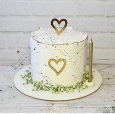 a white cake with gold hearts on top