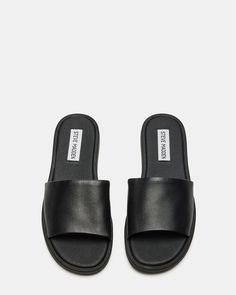 CHILL + SLEEK + CLEAN A monochrome design and a wide strap gives the flat KAYA slide its classic look. Slide sandal Slip-on style .5 inch heel height Leather upper material Synthetic lining Synthetic sole Imported Classic Black Slides With Textured Footbed, Classic Slides With Leather Footbed, Classic Slides With Removable Insole, Classic Open Toe Slides With Rubber Sole, Classic Black Slip-on Slides, Classic Black Summer Slippers, Classic Black Flat Slides, Classic Black Slippers For Summer, Classic Flat Slides With Removable Insole