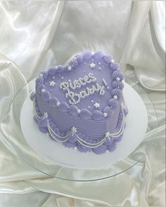 a heart shaped cake with the words happy birthday on it sitting on a glass plate