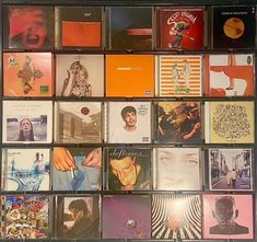 many cds are stacked on top of each other in a display case with the same color and size