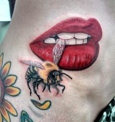 a woman's stomach with a bee on it and the lip painted to look like a mouth