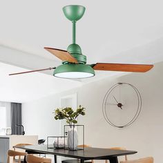 a green ceiling fan sitting above a dining room table