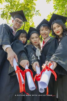 a group of people in graduation gowns holding diplomas