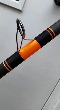 an orange and black bicycle handlebar with glasses resting on it's rims