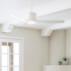 a white ceiling fan sitting above a window