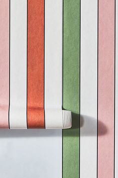 the wall is lined with multicolored vertical striped paper and has a white stripe on it