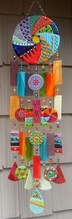 a colorful wind chime hanging from the side of a building