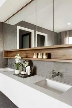 a bathroom with two sinks, mirrors and candles on the counter top next to each other