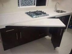 a kitchen with a stove top oven next to a sink and countertop in front of a window