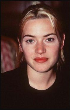 a close up of a person wearing a black shirt and looking at the camera with a serious look on her face