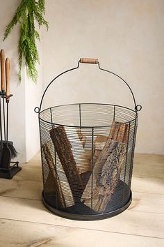 a wire basket with bread in it sitting on the floor next to candles and other items