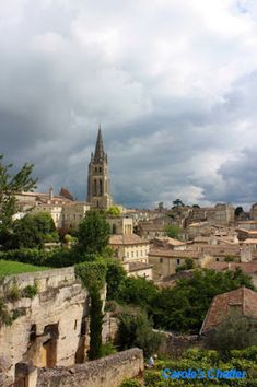 the city is surrounded by old buildings and green trees, with dark clouds in the background