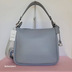 Brand New With Tags. Grey Blue Color. A Laidback Slouchy Silhouette Style Bag With A Roomy Interior And Several Pockets For Easy Organization. Crafted Of Soft Pebble Leather With An Exterior Back Zip-Pocket For Added Storage And Easy Access. It Comes With A Detachable Top Handle And A Long Strap For Shoulder Or Crossbody Wear. It’s Finished With A “C” Logo Dangle And Leather Hangtag For Added Detail. Features: Soft Pebbled Leather Top-Zip Closure Fabric Lining Brass/Gold-Tone Hardware. 2 Charms Coach Shoulder Satchel With Silver-tone Hardware, Casual Coach Shoulder Bag With Silver-tone Hardware, Coach Shoulder Bag With Silver-tone Hardware For Daily Use, Coach Blue Shoulder Bag With Silver-tone Hardware, Coach Tote Bags With Silver-tone Hardware, Leather Top, Pebbled Leather, Coach Bags, Leather Shoulder Bag