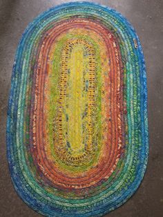 a multicolored rug on the floor with an oval shaped area rug in the middle