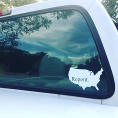 a white truck with the word repent written on it's side window in front of trees