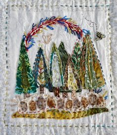 a quilted wall hanging with trees on it