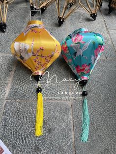 two chinese lanterns with tassels are on the ground