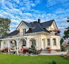 a large white house sitting on top of a lush green field