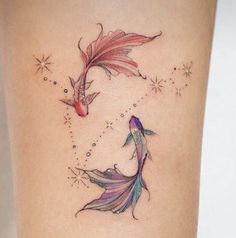 a woman's thigh with two colorful fish tattoos on it