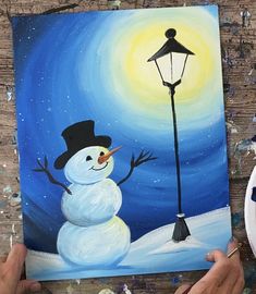 someone is painting a snowman with a lamp post