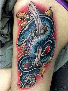 a woman's thigh with a blue snake tattoo on it